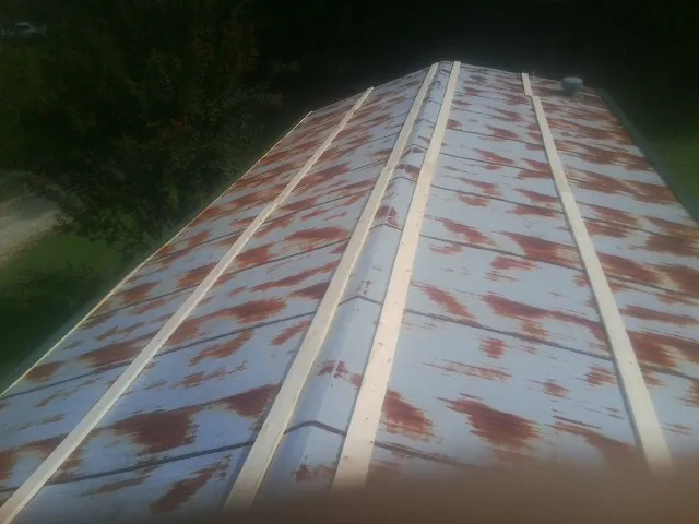 Rusted metal roof panels with new wood purlins before replacement — Storm Damage Roof Repair in Sterling Heights by Roofing Brothers