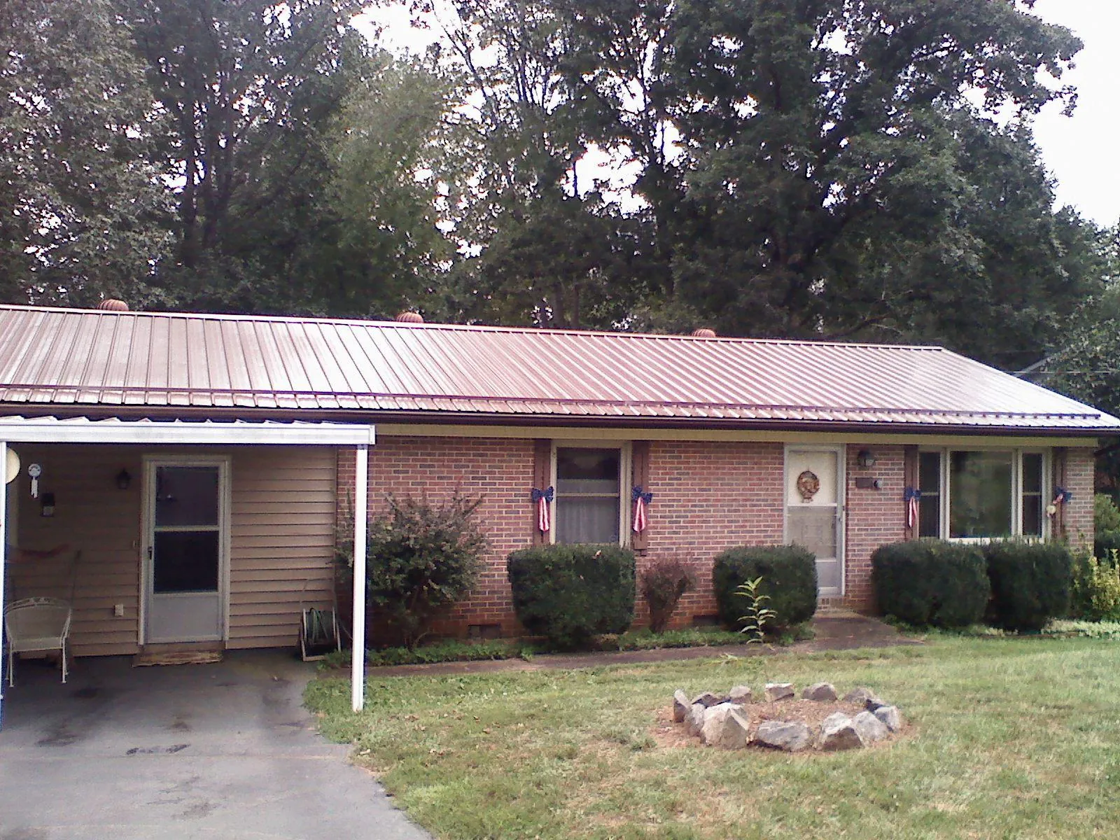 Bronze metal roof and carport on a brick ranch home — Roof Repair work by our crew in Sterling Heights